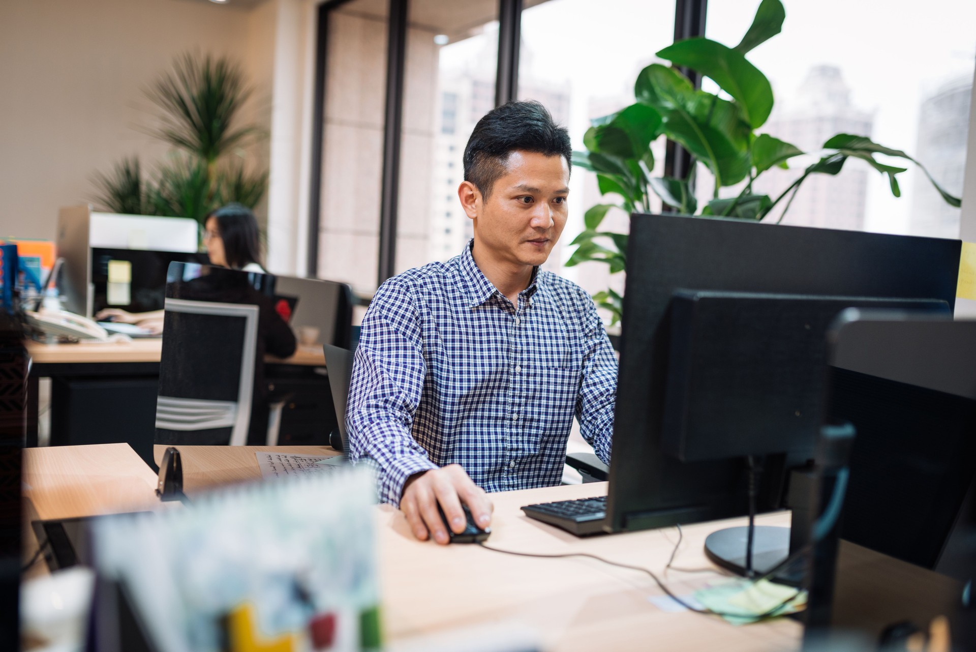 Trabajador administrativo en Asia, trabajando en computadora.