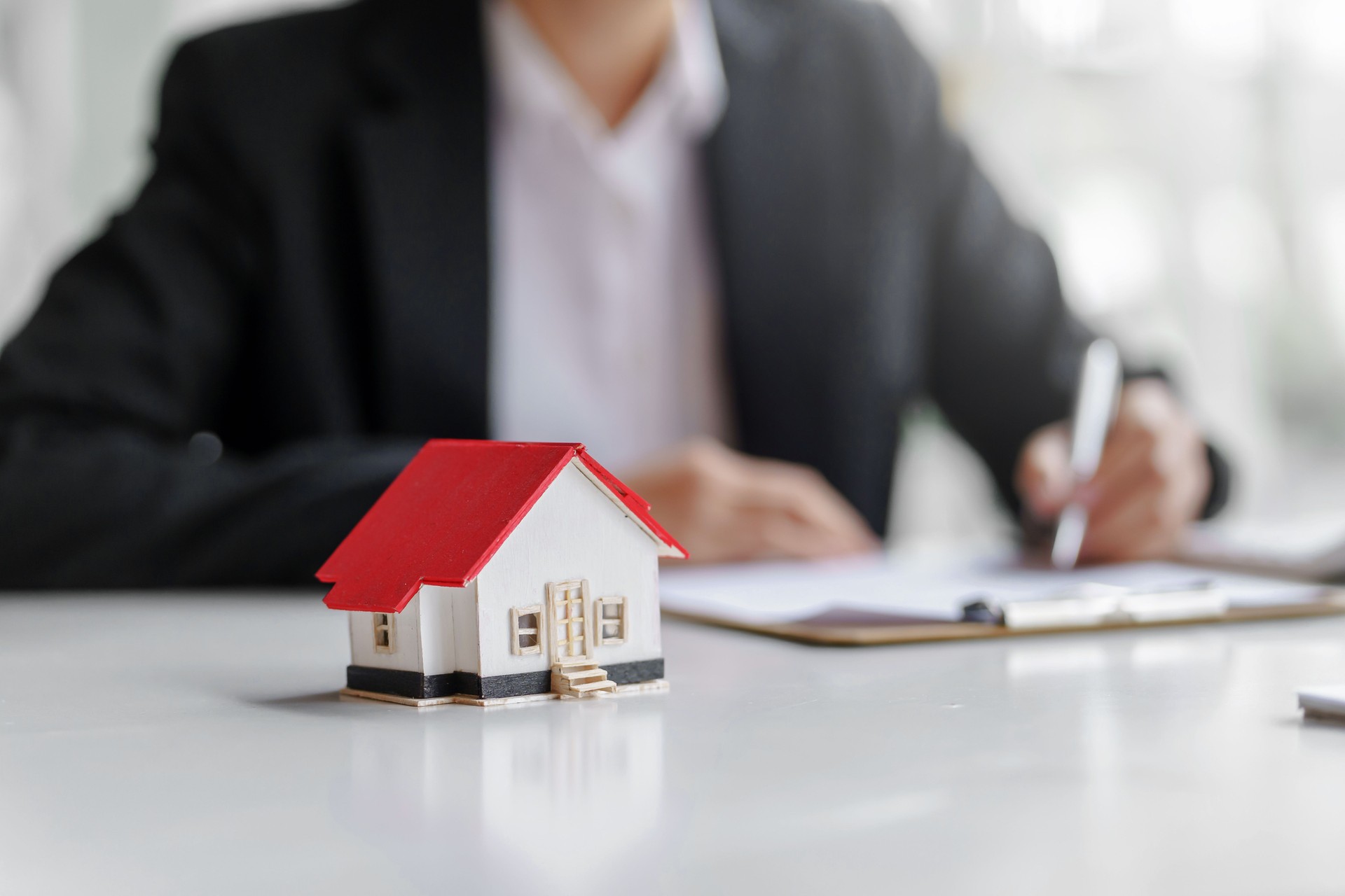 Agente inmobiliario ofrece diseño y contrato de casas. Aprobación de un contrato de compra o venta de una vivienda. Ofrece préstamos hipotecarios y concepto de seguro de hogar.