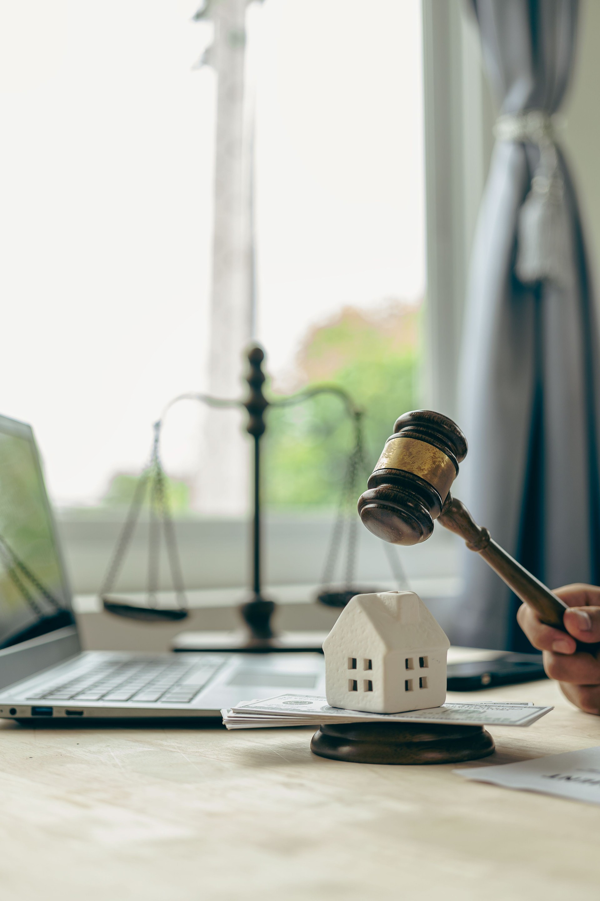 Subasta de la propiedad Mano de la mujer que sostiene un martillo de madera y la casa modelo de un abogado de bienes raíces en una casa y concepto de propiedad en la subasta de la propiedad, las finanzas y la ejecución hipotecaria. Concepto de propiedad